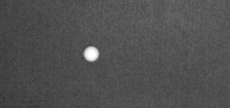 Looping slow-motion sequence from above: an iron head sweeps through the ball on the mat
